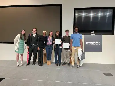 Group of students standing by a podium